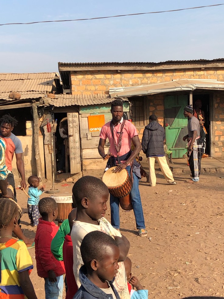 photo of Namory drumming while standing in a group of people outside